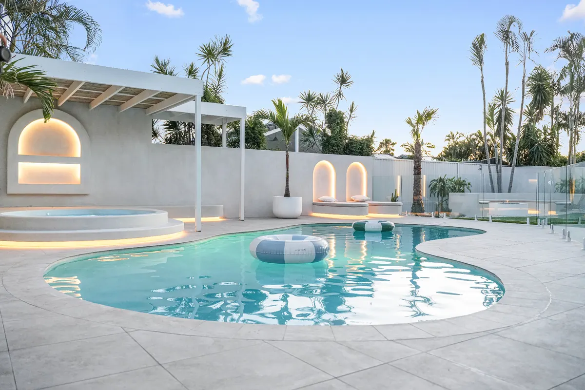 Resort-style freeform concrete pool with arched feature wall and spa, Mermaid Waters